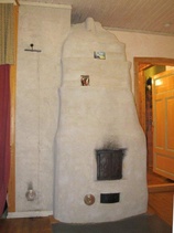 Tulisija keskeisellä paikalla lämmittää taloa mukavasti.